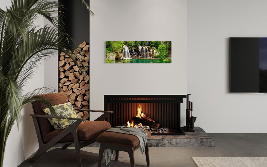 A piece of Colorado art showing a photo of the Hanging Lake waterfall hangs over a fireplace.