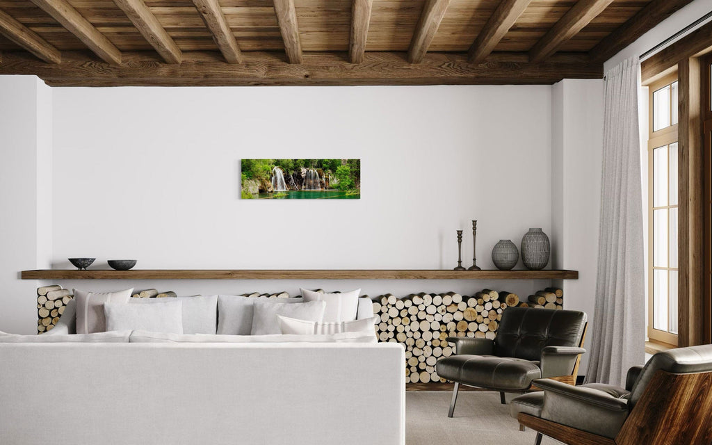 A piece of Colorado art showing a photo of the Hanging Lake waterfall hangs in a rustic living room.