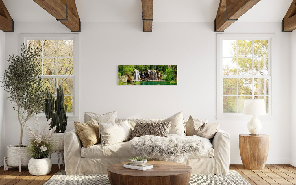 A piece of Colorado art showing a photo of the Hanging Lake waterfall hangs above a couch.