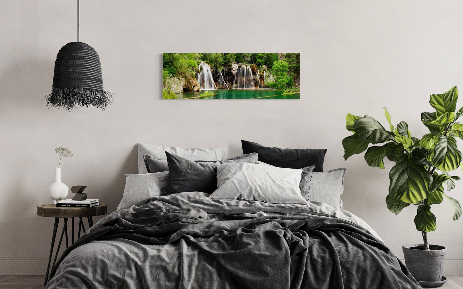 A piece of Colorado art showing a photo of the Hanging Lake waterfall hangs in a bedroom.