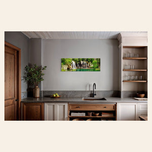 A piece of Colorado art showing a photo of the Hanging Lake waterfall hangs in a kitchen.