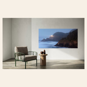 A piece of Oregon wall art showing Heceta Head Lighthouse hangs in a living room.