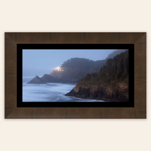 A piece of framed Oregon wall art shows Heceta Head Lighthouse.