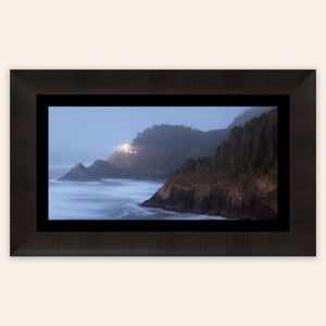 A piece of framed Oregon wall art shows Heceta Head Lighthouse.