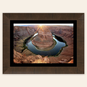 A piece of framed Arizona art shows a Horseshoe Bend sunset picture.