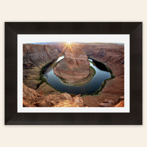 A piece of framed Arizona art shows a Horseshoe Bend sunset picture.