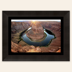 A piece of framed Arizona art shows a Horseshoe Bend sunset picture.