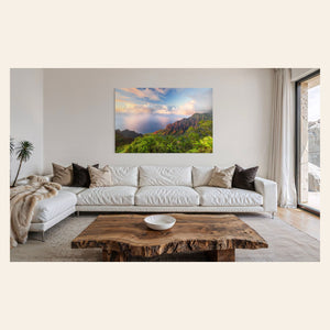 A piece of Kauai art showing a photo of sunset at the Napali Coast as seen from the Kalalau Valley Overlook hangs in a living room.