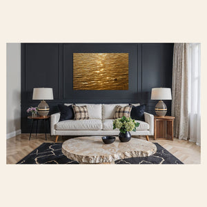 A piece of Kauai art showing a photo of a Kapaa sunrise reflected in the water hangs in a living room.