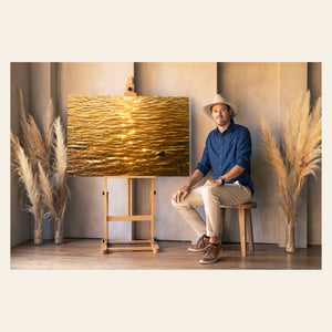 West Seattle artist Lars Gesing with his Kauai art showing a Kapaa sunrise reflected in the ocean.