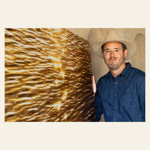 Lars Gesing with his Kauai artwork showing a Kapaa sunrise being reflected in the water.