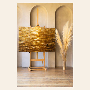 A piece of Kauai art by Lars Gesing shows a photo of a Kapaa sunrise reflected in the ocean.