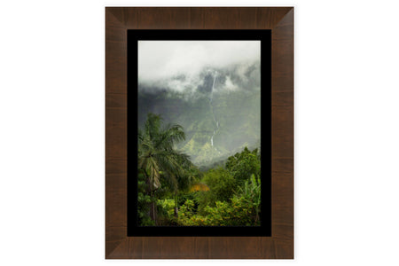 A piece of framed Kauai art shows a waterfall picture outside of Hanalei.