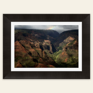 A framed picture of Waimea Canyon on Kauai with a rainbow.