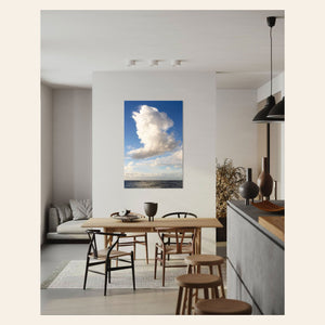 A piece of Kauai art showing a cloud photo over the ocean hangs in a kitchen.
