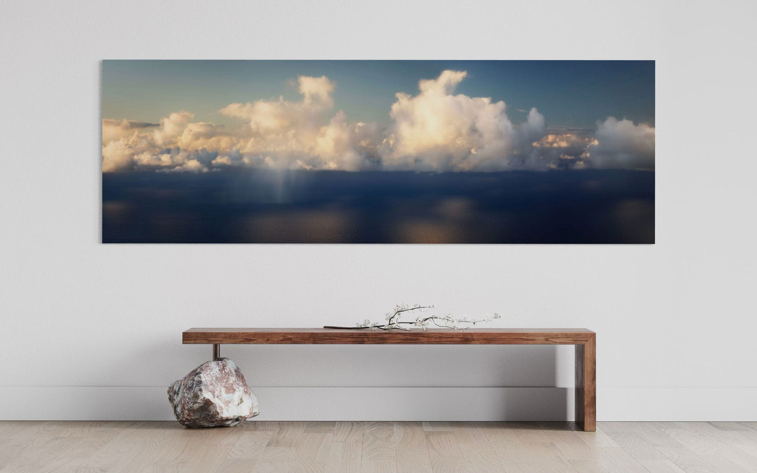 A piece of Kauai art showing a photo of clouds along the Napali Coast hangs above a bench.