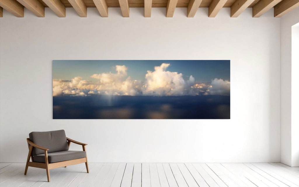 A piece of Kauai art showing a photo of clouds along the Napali Coast hangs in a minimalist sitting area.