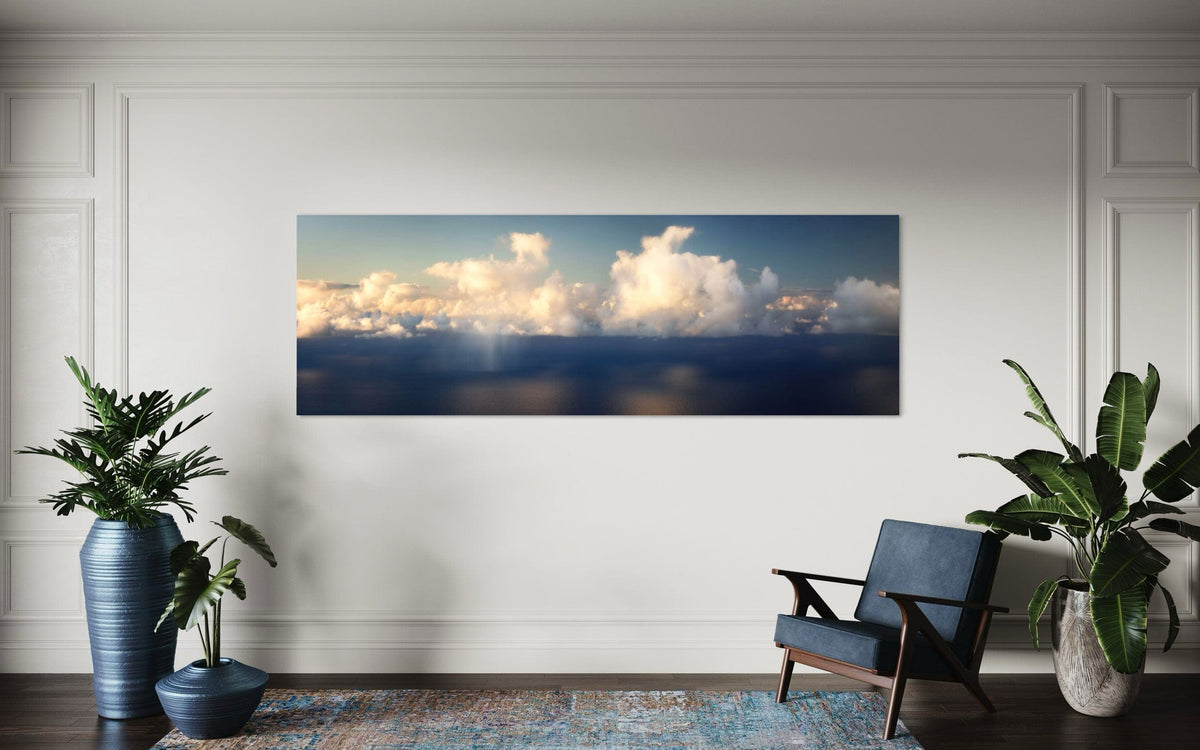 A piece of Kauai art showing a photo of clouds along the Napali Coast hangs in a sitting area.