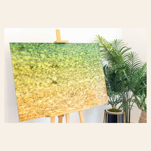 A piece of Kauai art showing the colors of the water on the ocean surface sits in a coastal-inspired room.