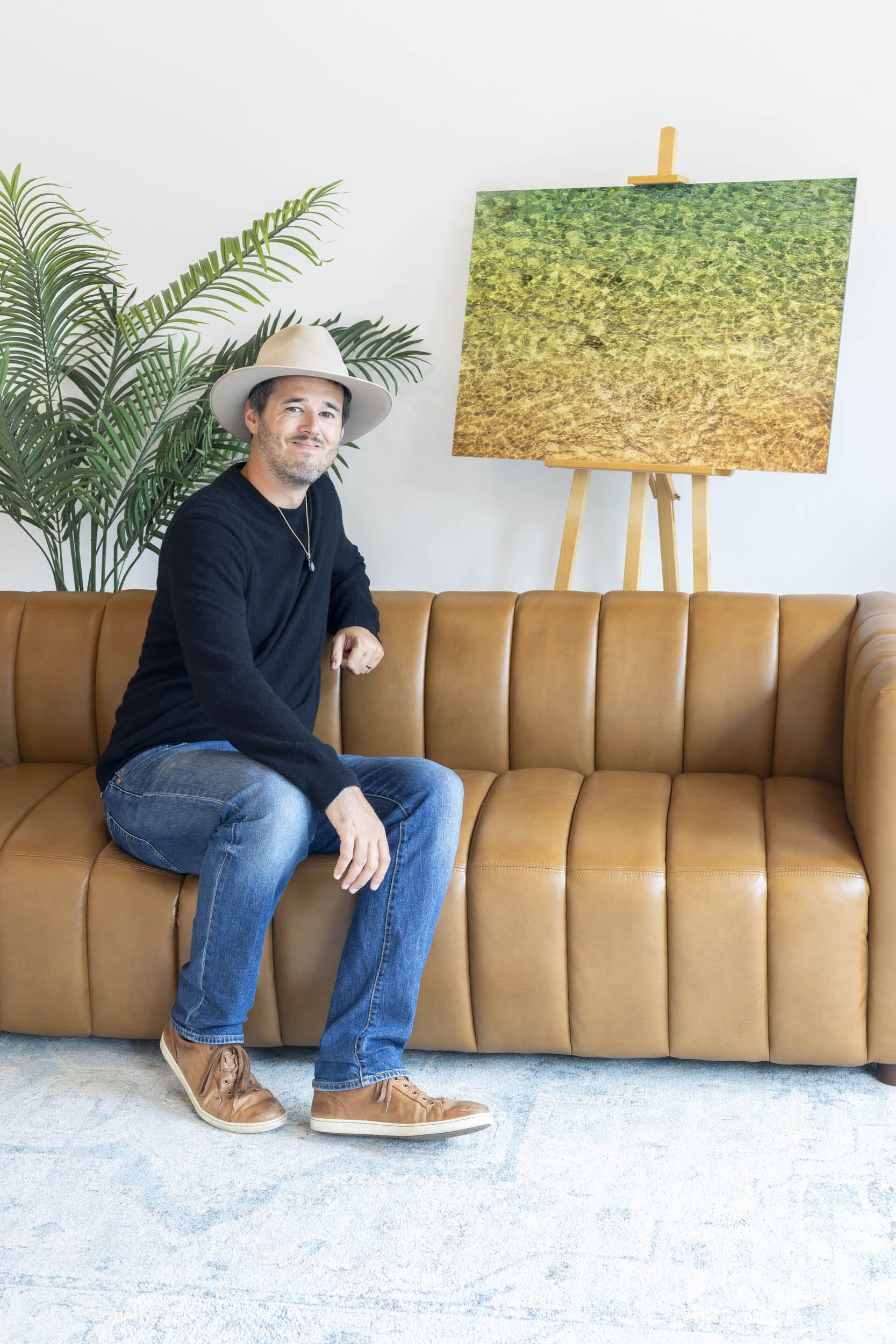 West Seattle artist Lars Gesing with his piece of Kauai art showing the colors of the water on the ocean surface.