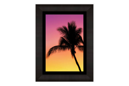 A framed Key West sunset picture with a palm tree.