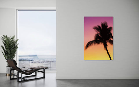 A Key West sunset picture with a palm tree hangs in a living room.