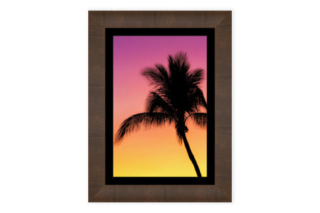 A framed Key West sunset picture with a palm tree.