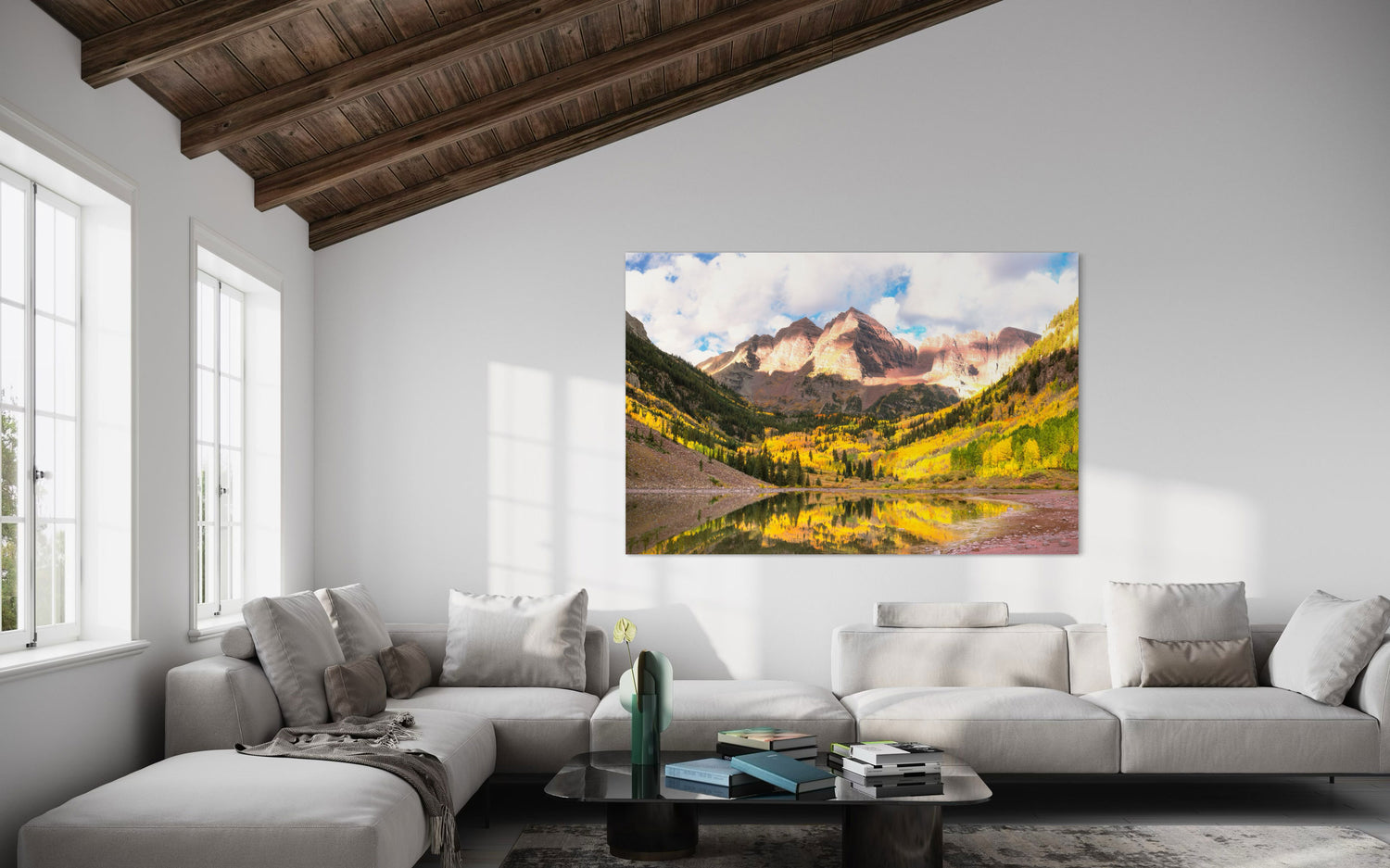 Stunning artwork of the Maroon Bells in Aspen during fall hangs in a living room.