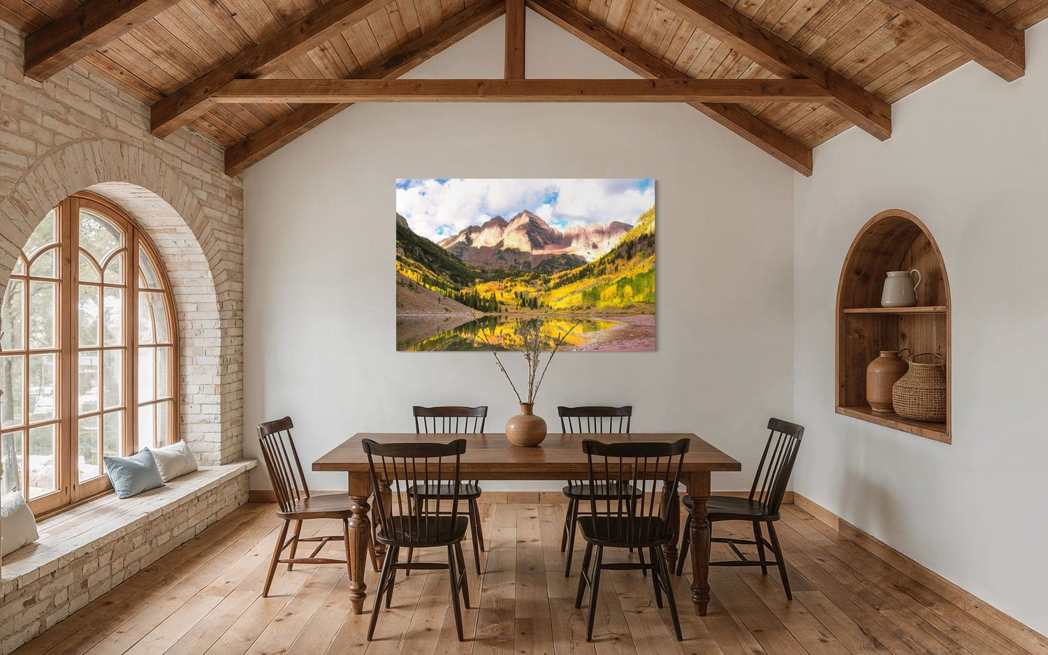 Stunning artwork of the Maroon Bells in Aspen during fall hangs in a dining room.