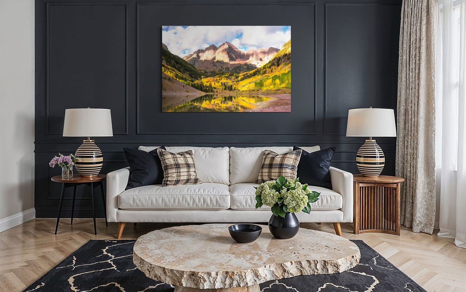 Stunning artwork of the Maroon Bells in Aspen during fall hangs above a couch.