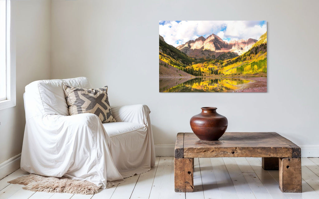 Stunning artwork of the Maroon Bells in Aspen during fall hangs in a sitting area.