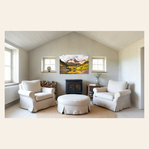 Stunning artwork of the Maroon Bells in Aspen during fall hangs in a living room.