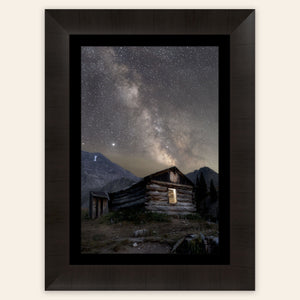 A framed piece of Colorado art shows photography of the milky way above Mayflower Gulch.