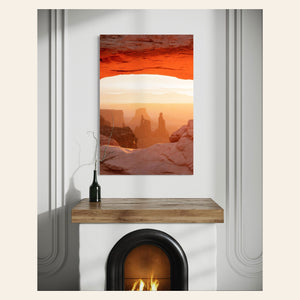 A piece of Moab art showing a Mesa Arch picture at sunrise hangs over a fireplace.