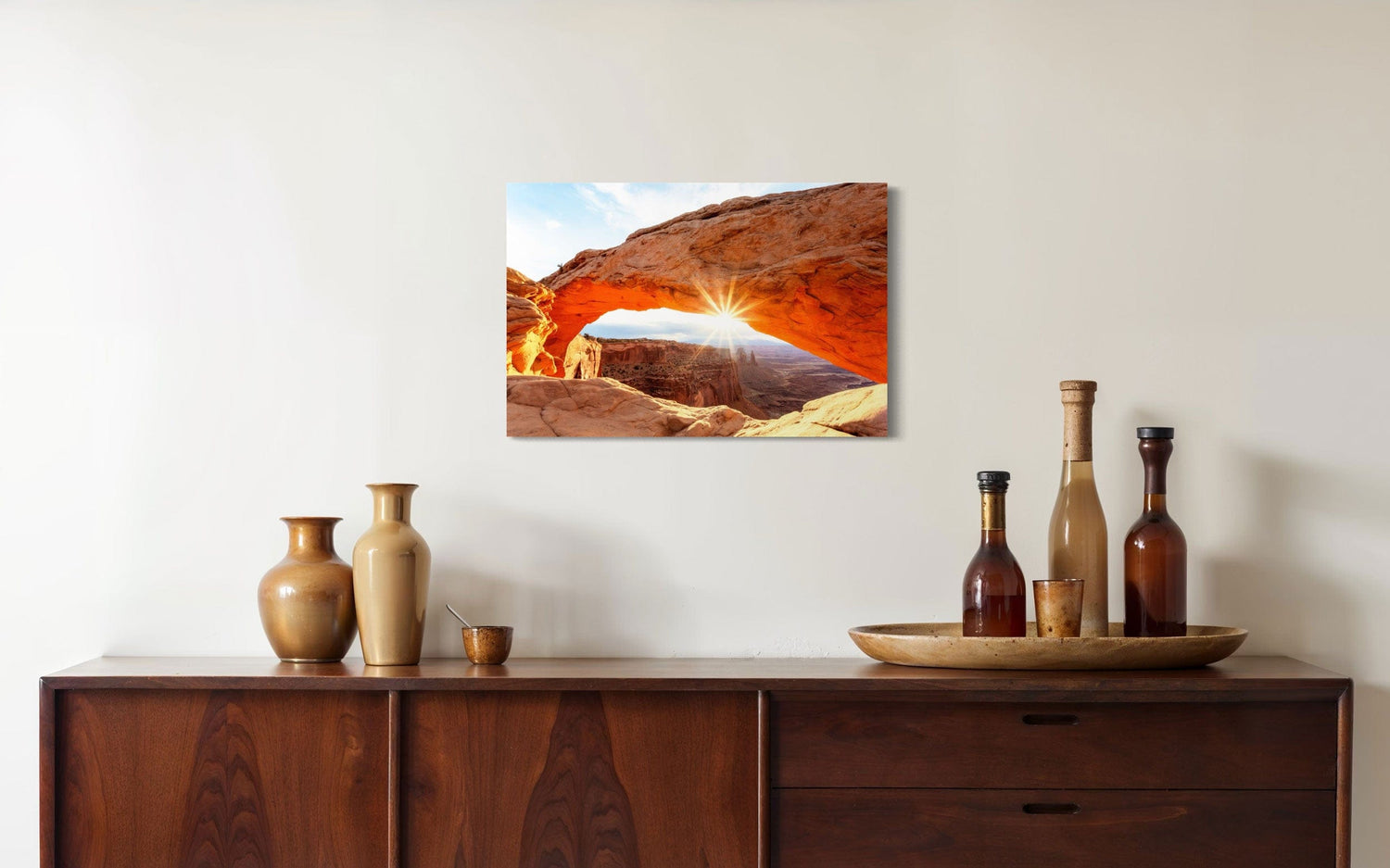 A piece of Moab art showing Mesa Arch in Canyonlands National Park hangs over a console.