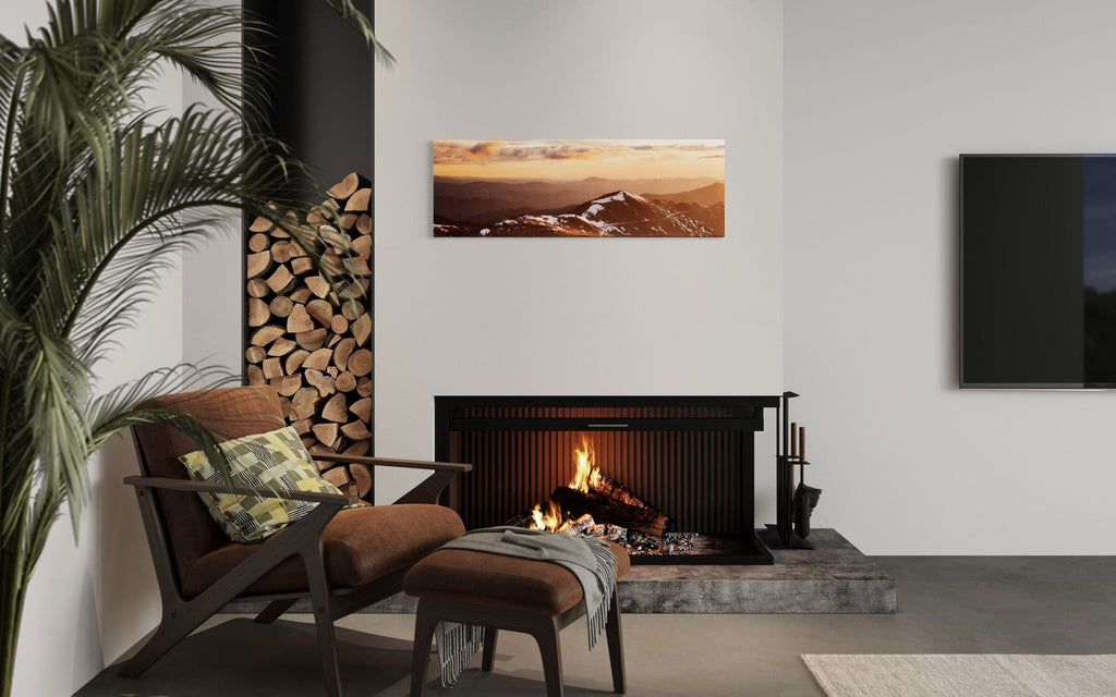 A piece of Colorado art showing a photo of Mount Evans at sunrise hangs above a fireplace.