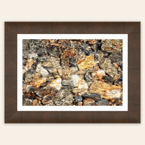 A piece of framed Telluride art shows a photo of a Colorado mountain stream.