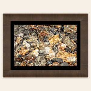 A piece of framed Telluride art shows a photo of a Colorado mountain stream.