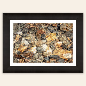 A piece of framed Telluride art shows a photo of a Colorado mountain stream.