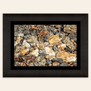 A piece of framed Telluride art shows a photo of a Colorado mountain stream.