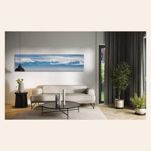 A piece of wall art showing an Olympic Mountains panorama photo hangs in a living room.