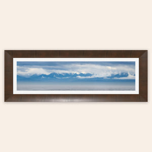 A piece of framed wall art shows an Olympic Mountains panorama photo.