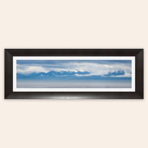 A piece of framed wall art shows an Olympic Mountains panorama photo.