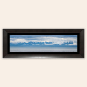 A piece of framed wall art shows an Olympic Mountains panorama photo.