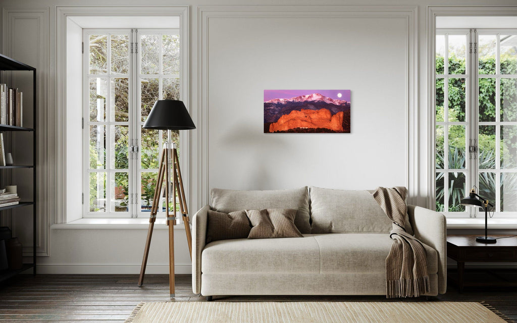 A piece of Colorado art showing a photo of Pike's Peak and the Garden of the Gods in Colorado Springs hangs above a couch.