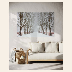 A piece of Seattle wall art showing Rockwood Farm in winter hangs above a couch.