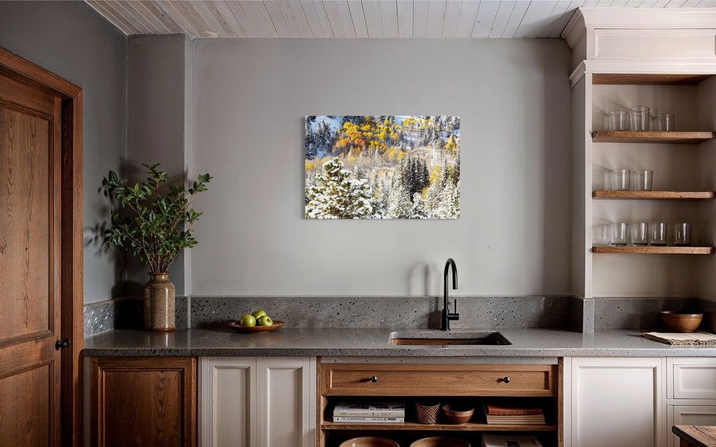 A piece of Rocky Mountain National Park art showing yellow aspen trees after snow in fall hangs in a kitchen.
