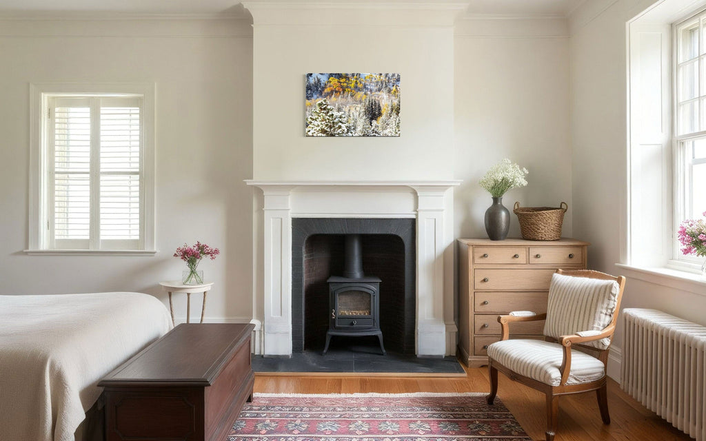 A piece of Rocky Mountain National Park art showing yellow aspen trees after snow in fall hangs above a bedroom fireplace.