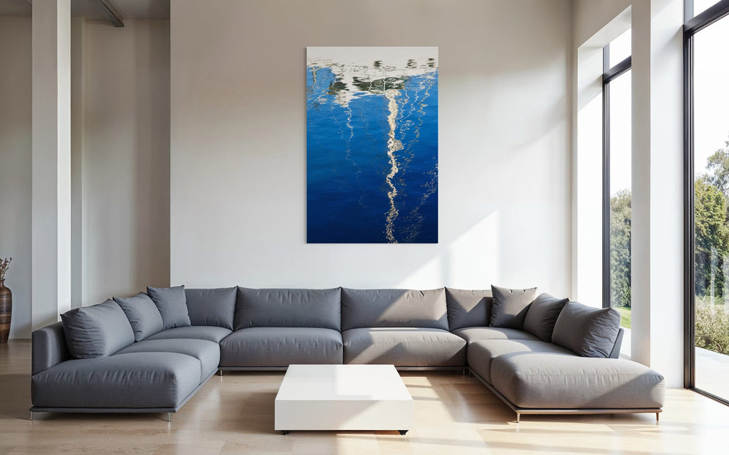 An abstract photo of a sailboat being reflected in the blue water of the San Francisco Marina hangs above a couch. | Lars Gesing Fine Art | Nautical Wall Art