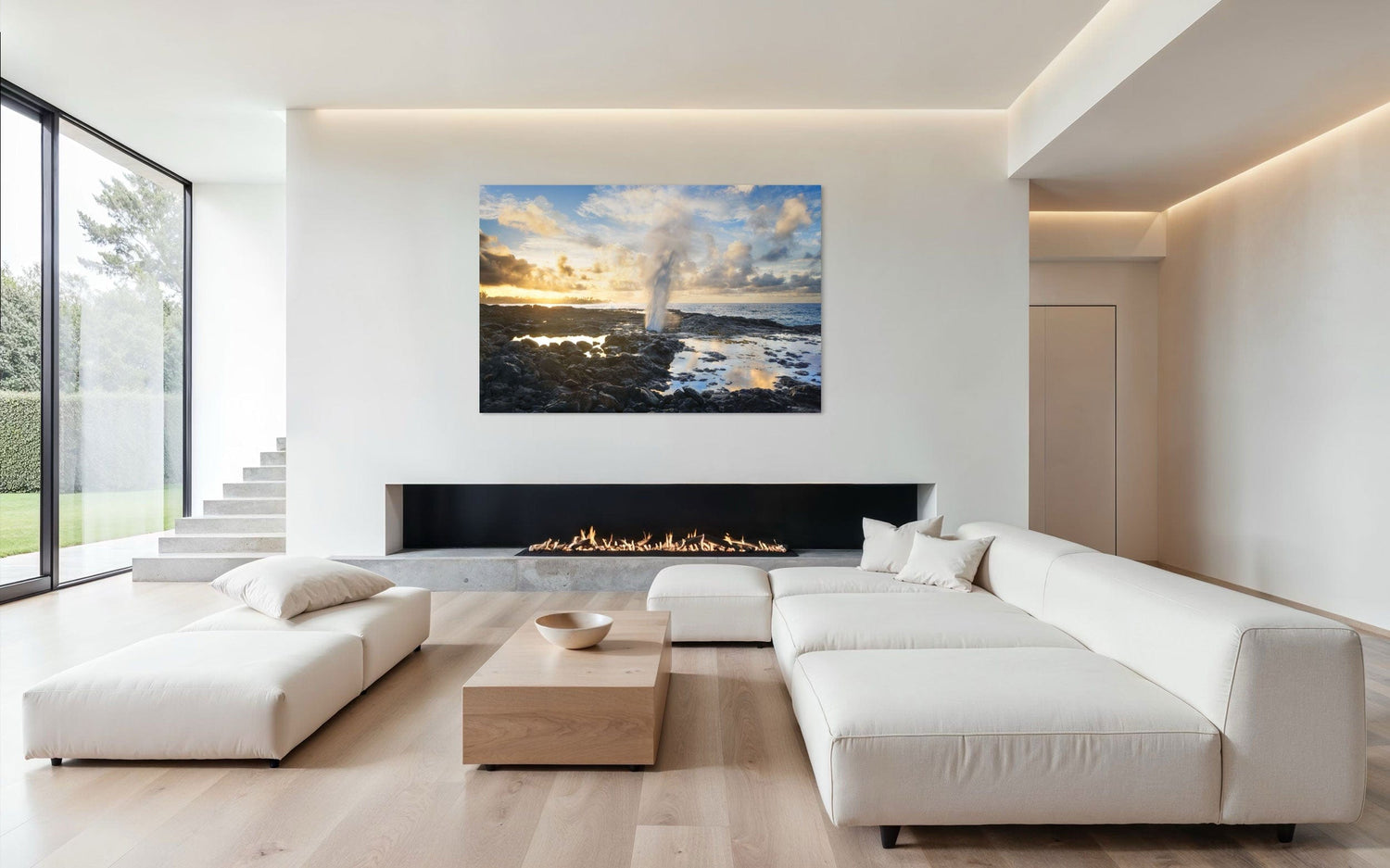 A piece of Kauai art showing a Spouting Horn photo hangs above a fireplace.